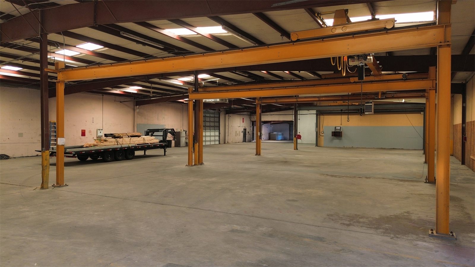 Warehouse interior at 4734 Potato House Court with orange steel framing, high ceilings, and an open concrete floor